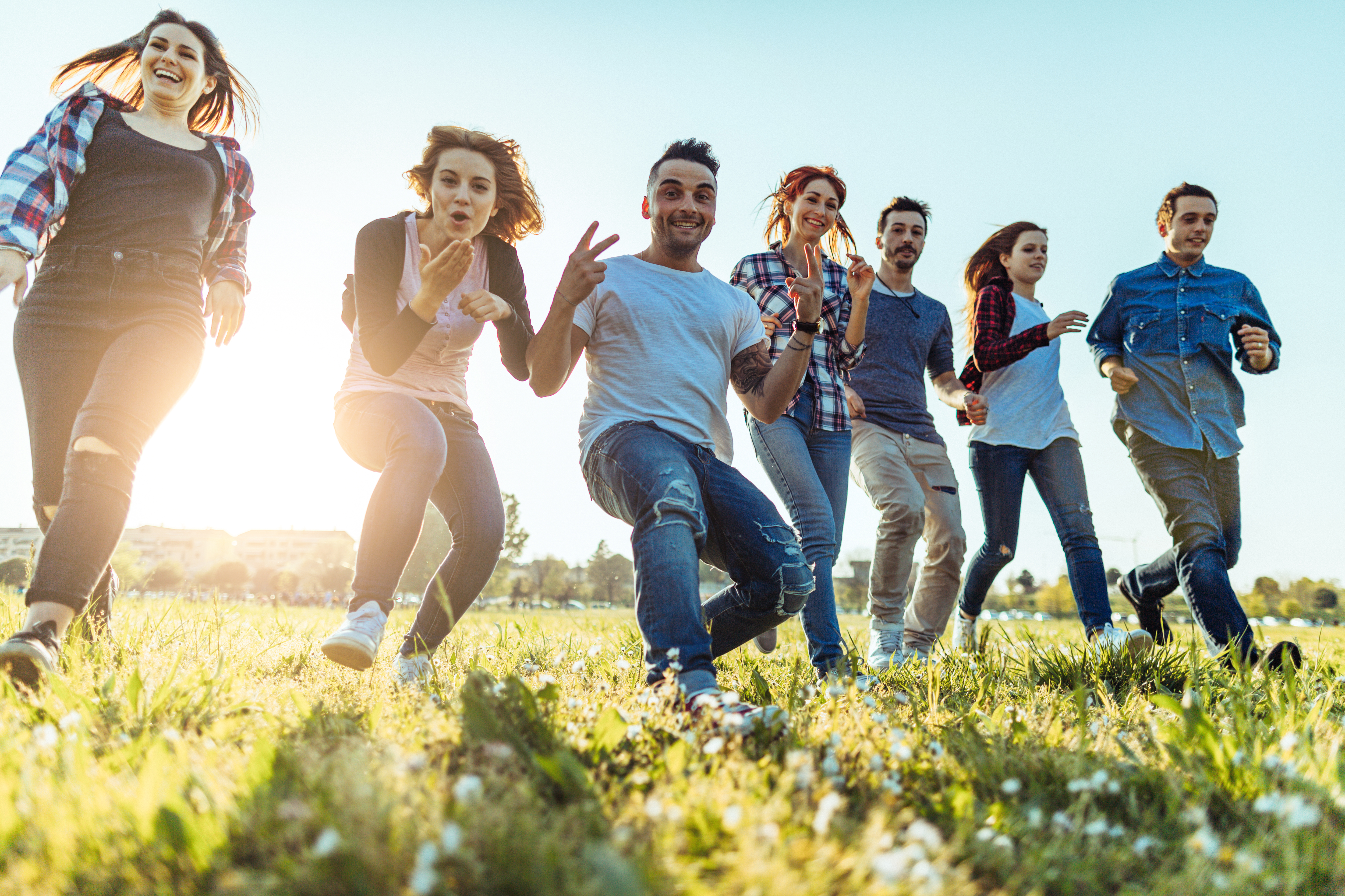 Group of friends in a city park, running together